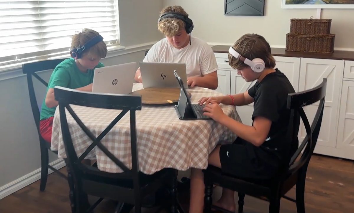 Three brothers at the kitchen table, each working on their own Homeschool Pro lessons